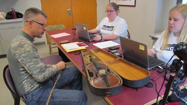 Students examine violin instrument