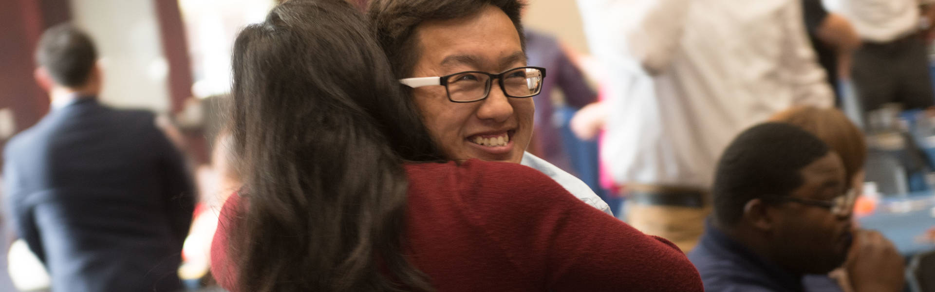 students embracing at OMA ceremony
