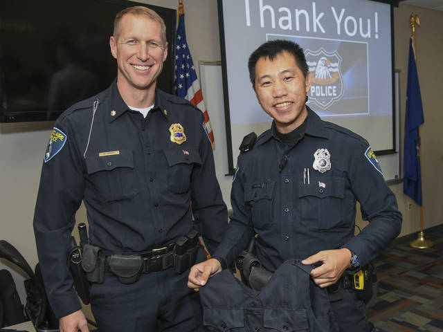 Matt Rokus, deputy chief of police, (left) issues Eau Claire police officer Mark Vang his load-bearing vest. 