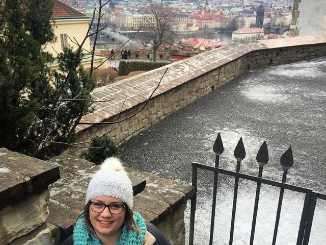 Allie Davies in the Czech Republic on a rooftop overlooking a city. 