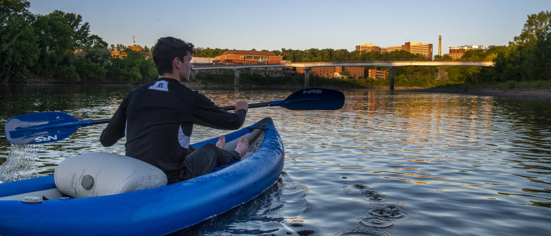 Student kayaking down river 