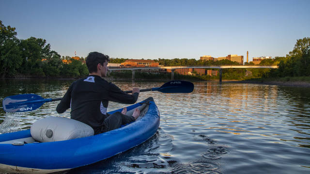 Student kayaking down river 