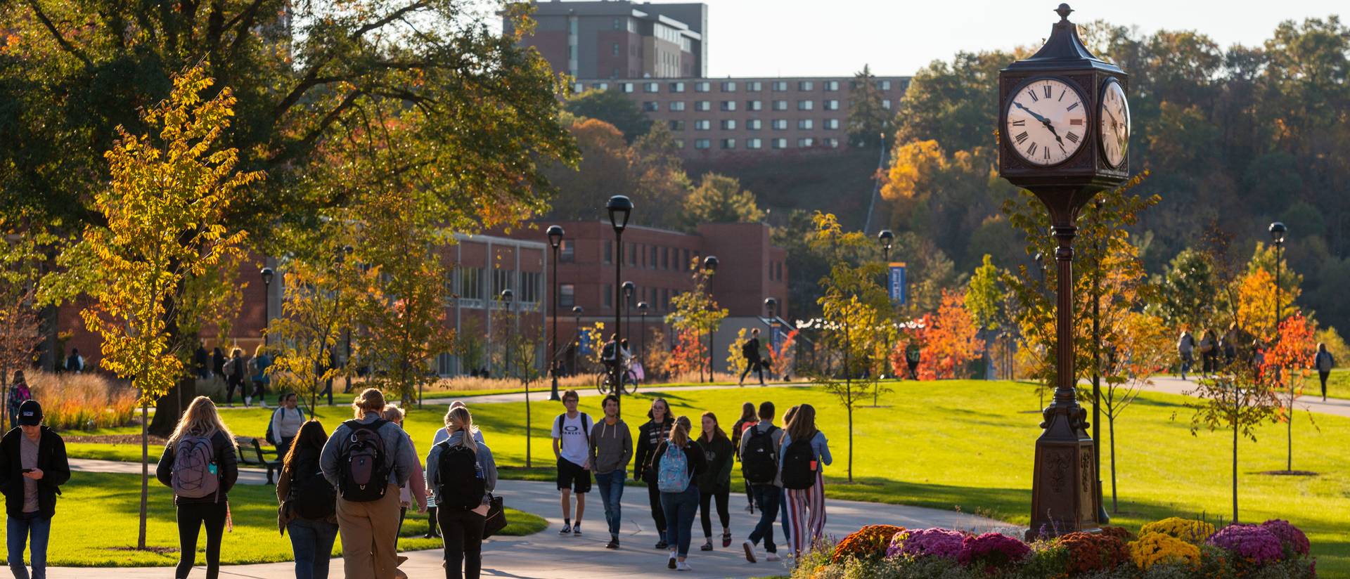 Students by clock tower in fall