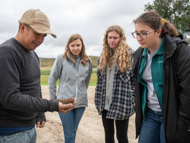 Farm worker Roberto Montalvo (left) talk with Blugolds Grace Johnson, Amanda Cassin and Bethany Johnson during the students’ visit to a western Wisconsin farm.
