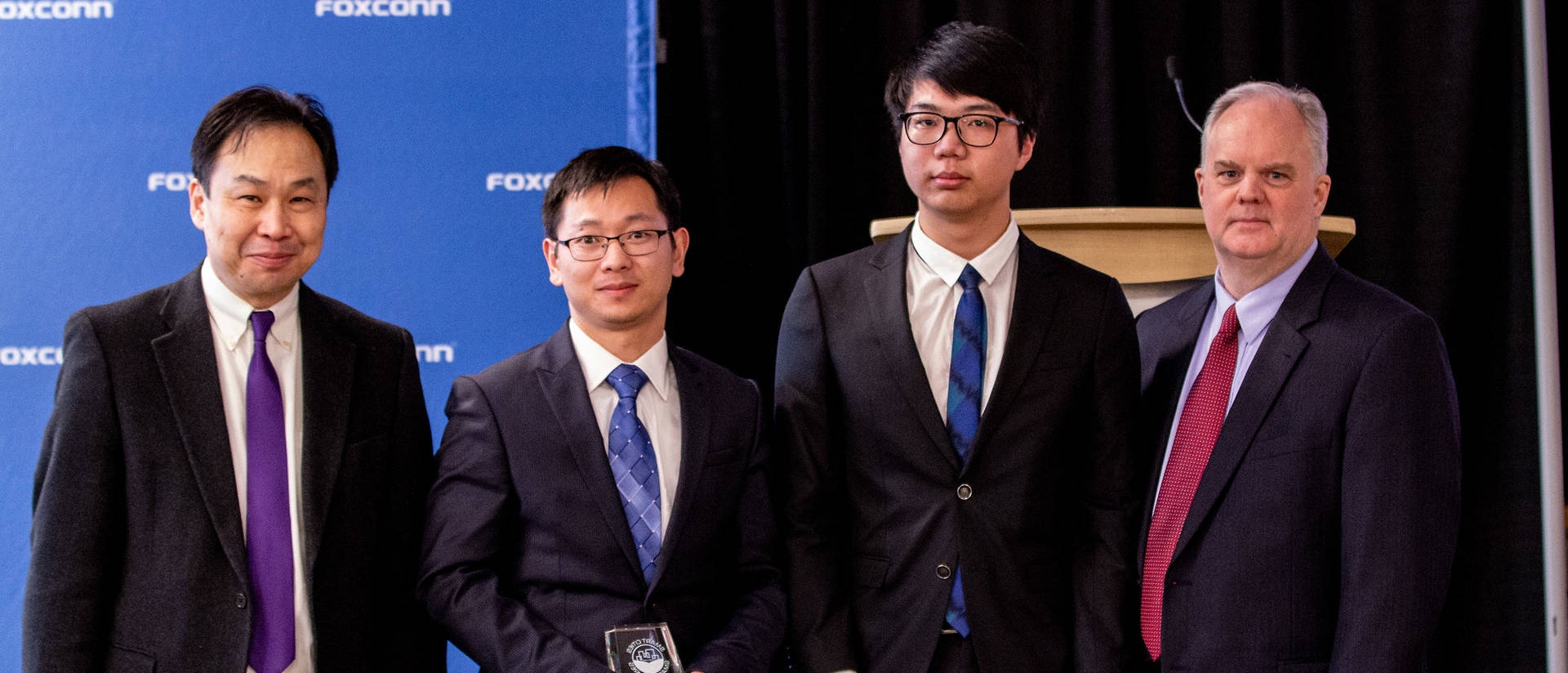 Dr. Wufeng Tian (second from left) and Huoyu Xu (third from left), along with FoxConn representatives at the Smart Cities-Smart Futures Competition. Xu is the student representative for the grand-prize team that created the B.E.S.T. Sign project.