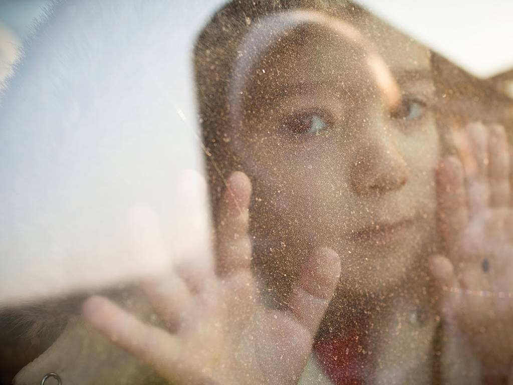 child looking through a foggy window