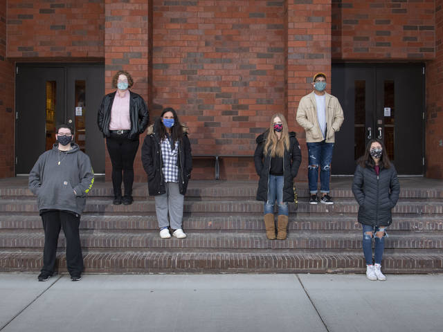 Peer Diversity Educators standing on steps wearing masks.