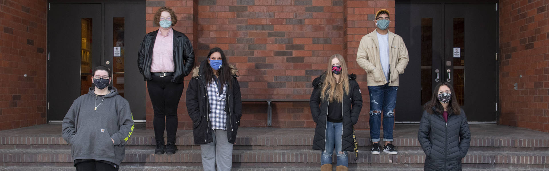 Peer Diversity Educators standing on steps wearing masks.