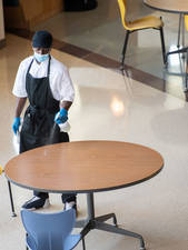 Student worker cleaning tables in Davies Marketplace