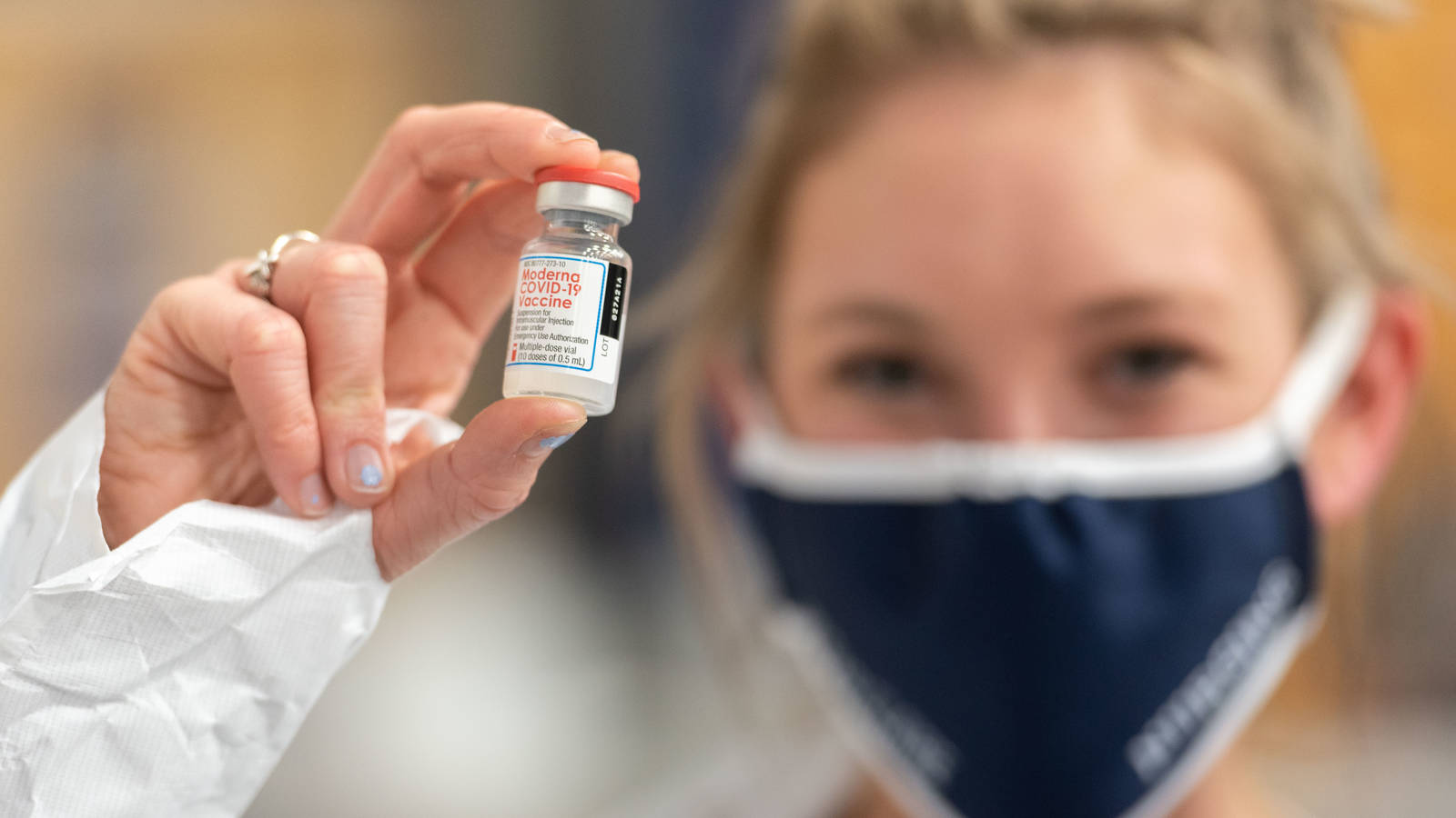 vial of Moderna vaccine held by nursing student