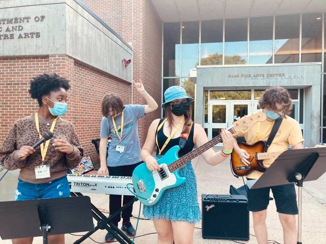 Students playing music outside Haas Fine Arts