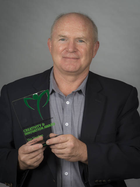 Tim Vaughn poses with an award