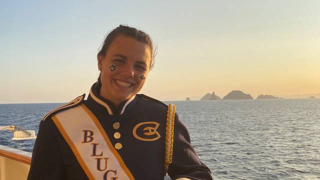 Girl in marching band uniform on the deck of a cruise ship