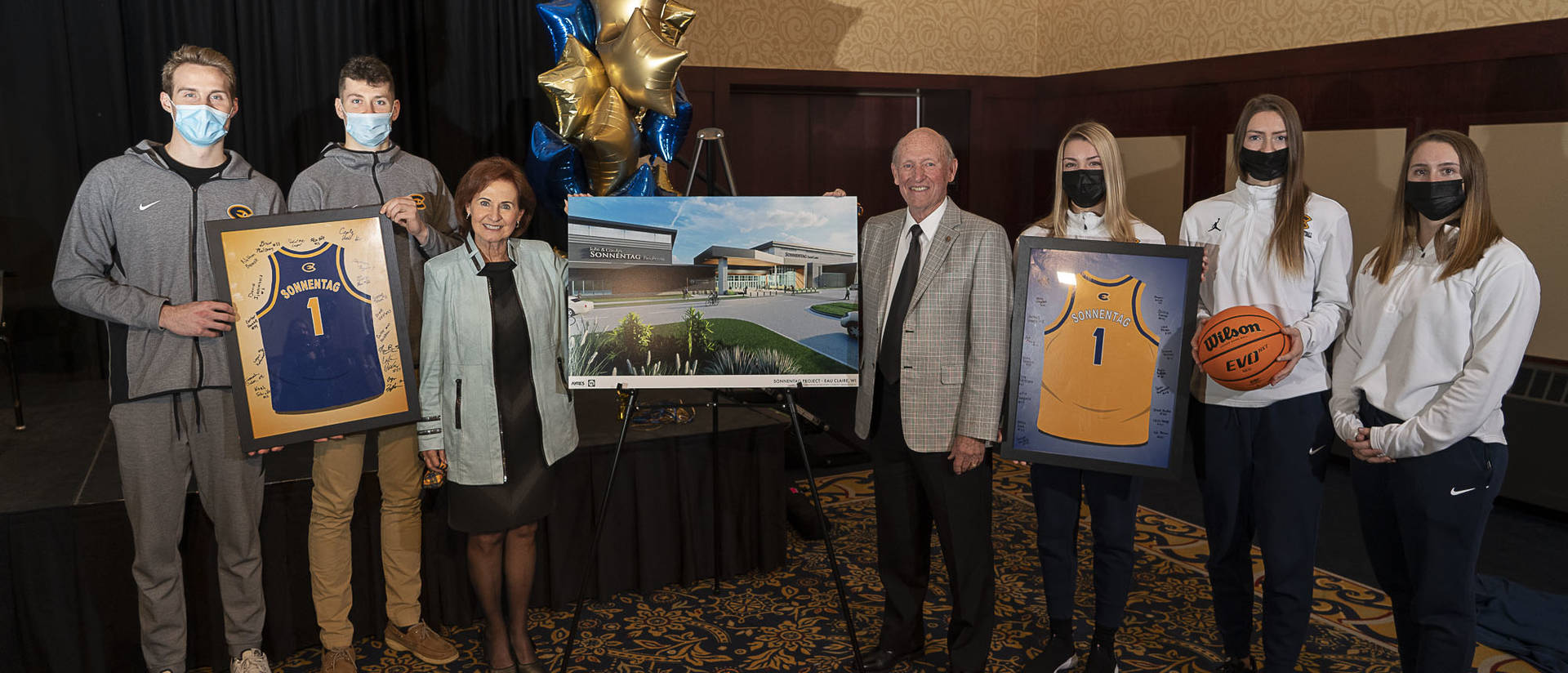 John and Carolyn Sonnentag stand with the members of the Blugold men's and women's basketball teams
