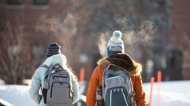 Students with backpacks outside, winter