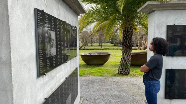 Female student looking at memorial wall at southern plantation