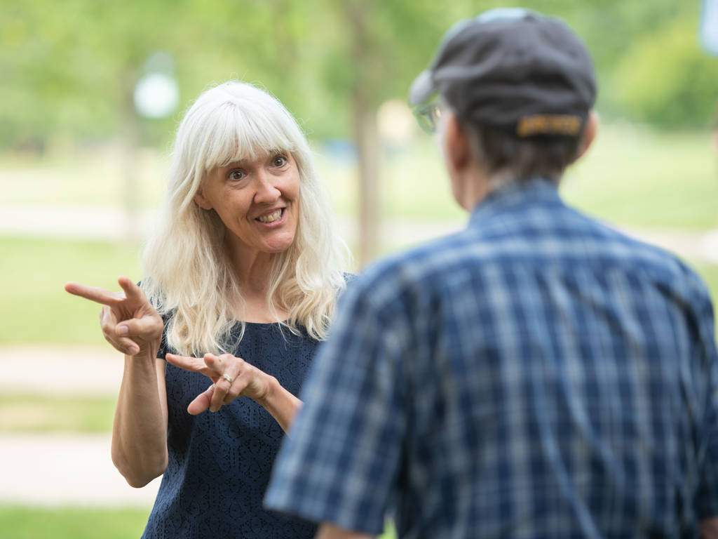 American Sign Language instructor speaking with community member