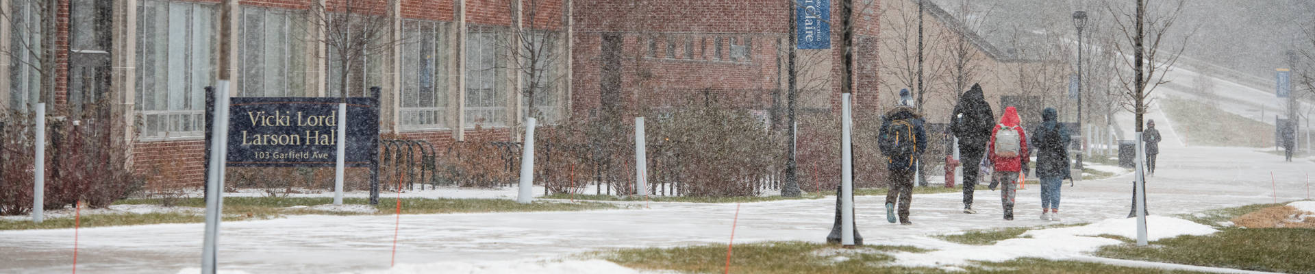 Students make their way through lower campus snow in this winter scene.