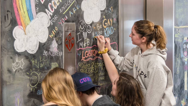 Students drawing on the chalkboard on the Rainbow Floor