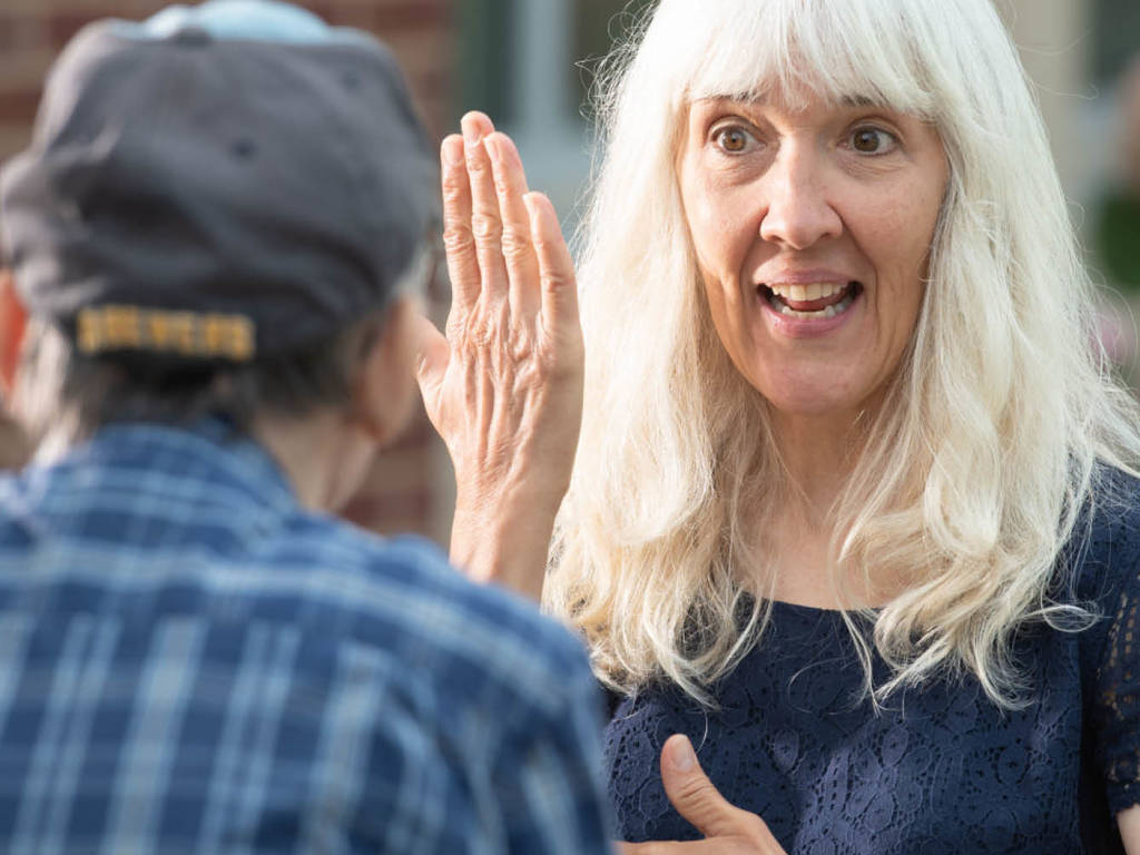 Instructor Rachel Kohn using sign language to communicate to a friend
