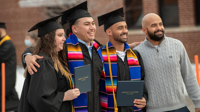 Commencement fall 2021, four students outside of Zorn Arena