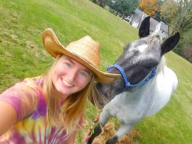 Girl in cowboy hat with a gray horse