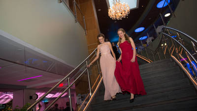Two people walking down the staircase at the Viennese Ball at UW-Eau Claire