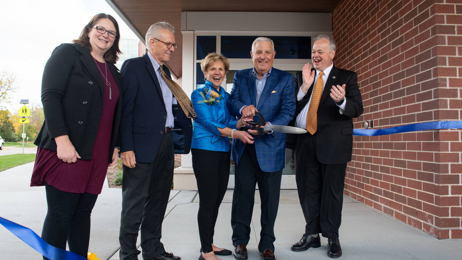 Tom and Jeannie Flesch (center) cut the ribbon at the dedication of the Flesch Family Welcome Center