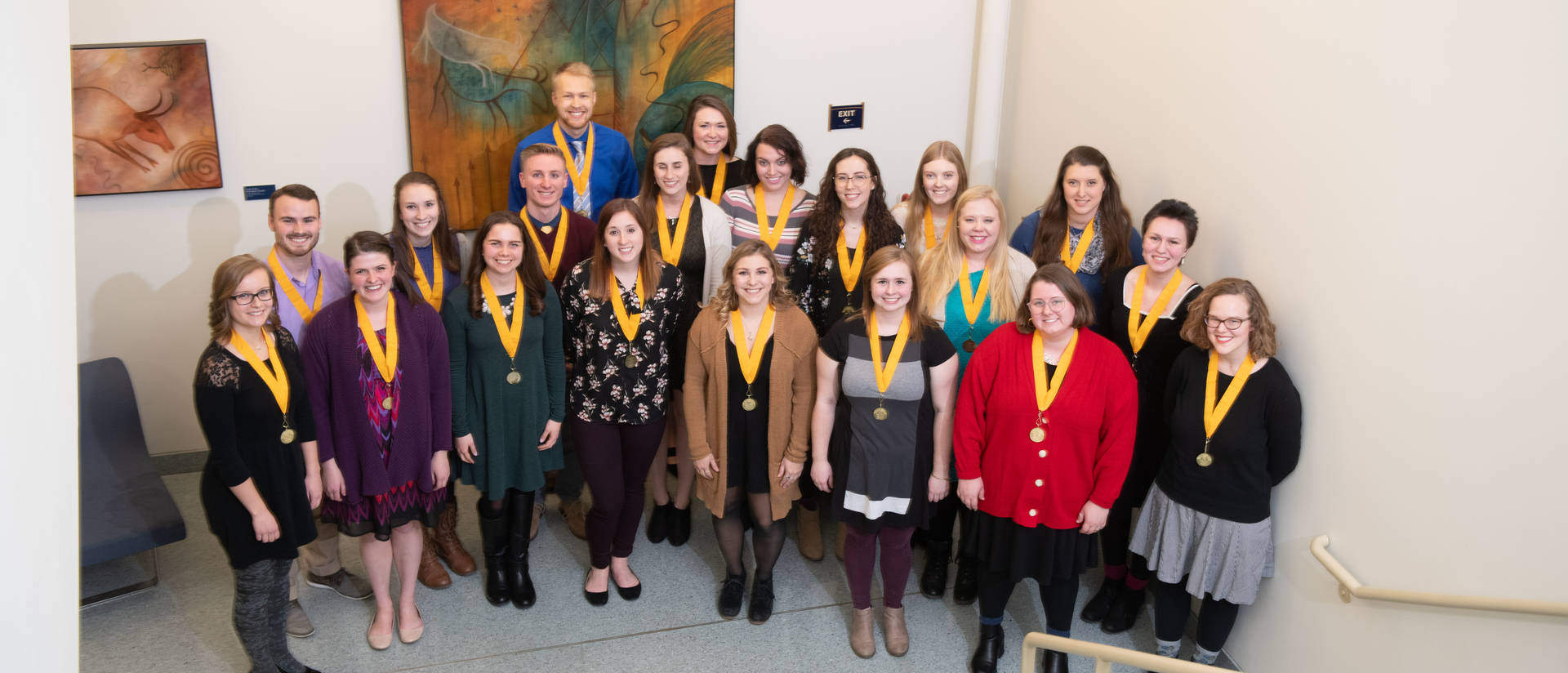 Students pose at an honors ceremony wearing medals.