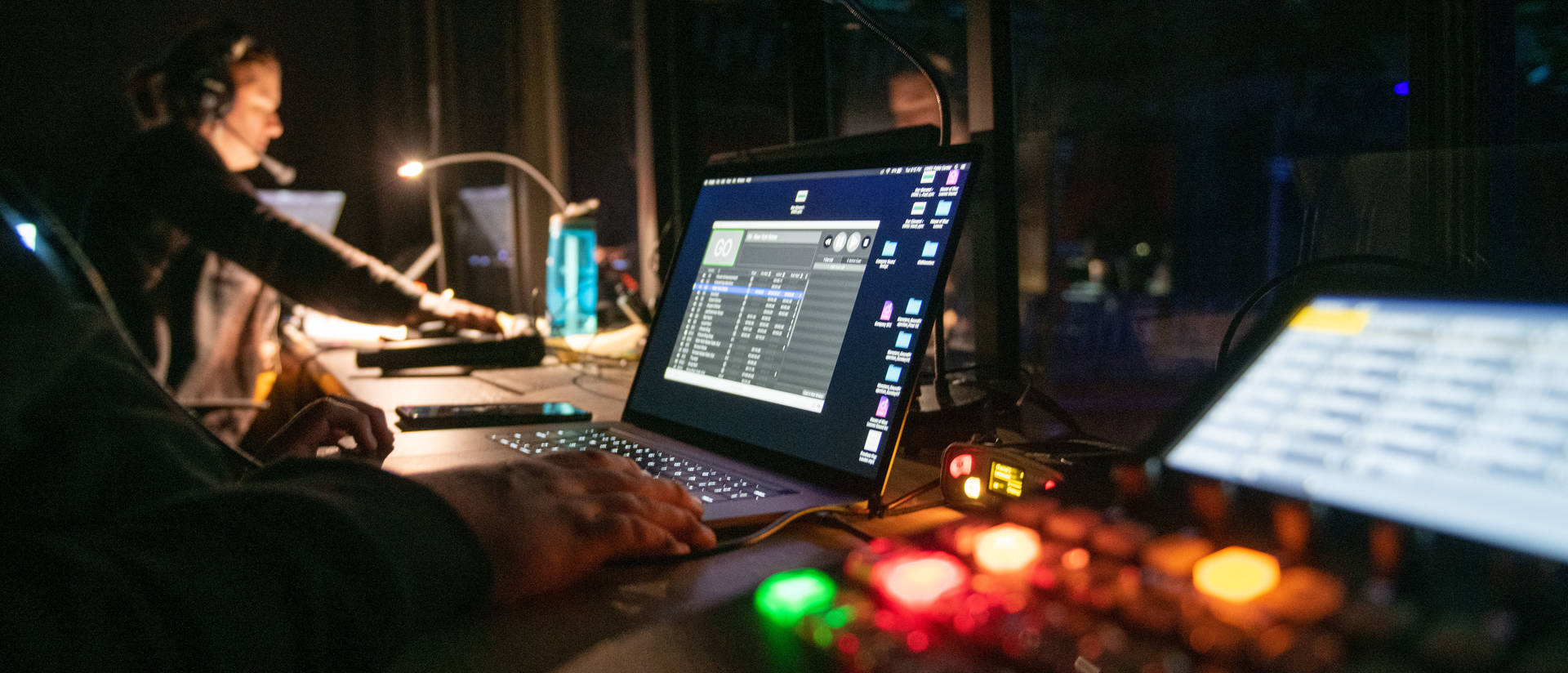 A closeup of theatre computers in the control room during a dress rehearsal