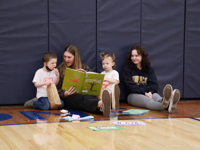 UW-Eau Claire students Julia Thompson (second from left) and Greta Westermeyer (right) read to children during the Spanish Literacy Event this spring. (Photo by José E. Chávez-Santiago)