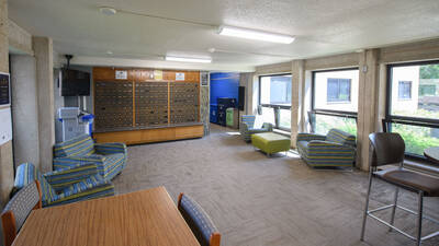 The lobby area of Sutherland hall featuring mailboxes, seating areas and tables