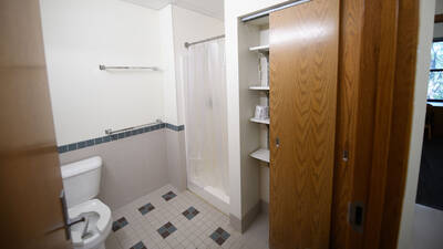 Bathroom space in a Chancellors Hall apartment with toilet, shower, and closet.