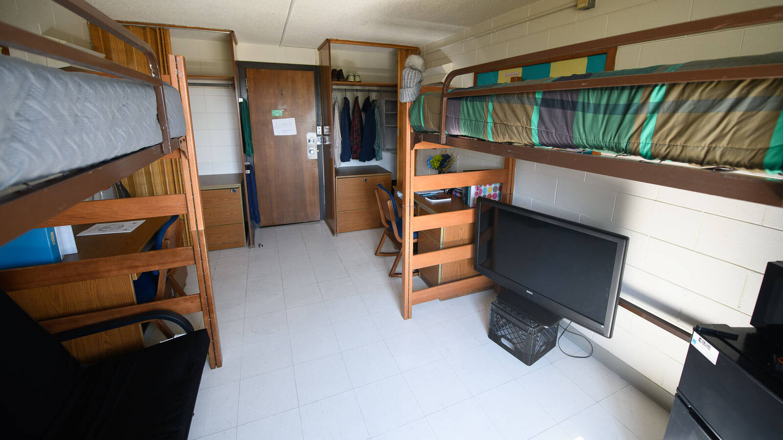Double room in Horan Hall (viewed from the wall opposite the door) with two beds, chairs, desks, and closet spaces.