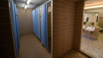 Horan Hall bathroom with tiled shower stalls with curtains.