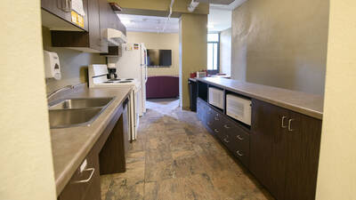 Shared kitchen in Priory Hall with microwaves, refrigerator, oven and plenty of counter space