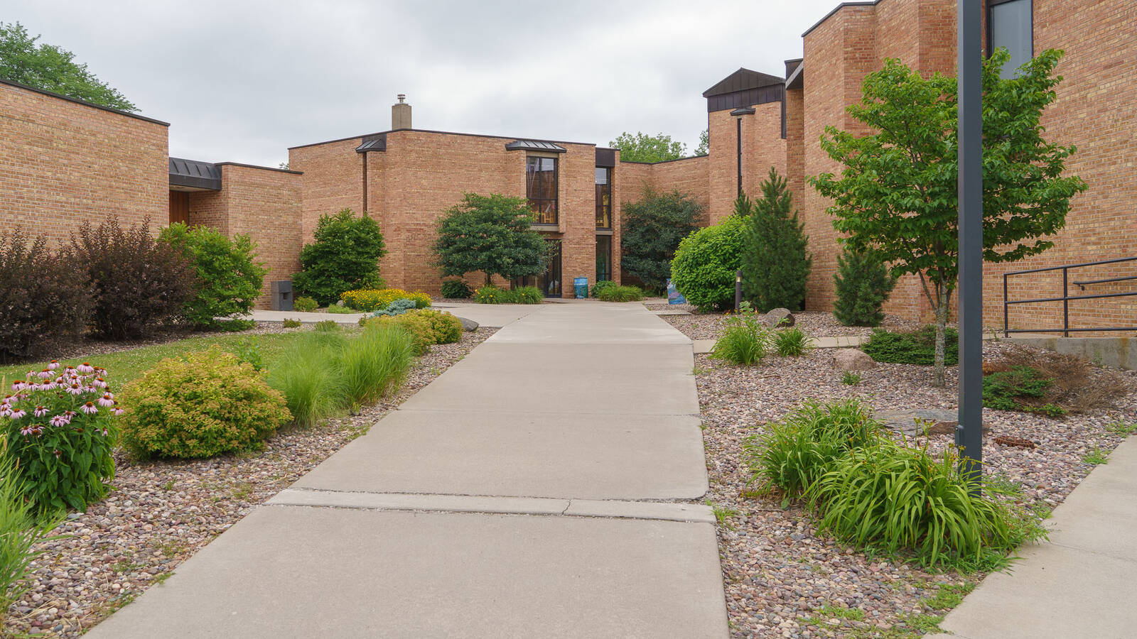 Exterior photo of Priory Hall, a brick residence hall with landscaping and sidewalks