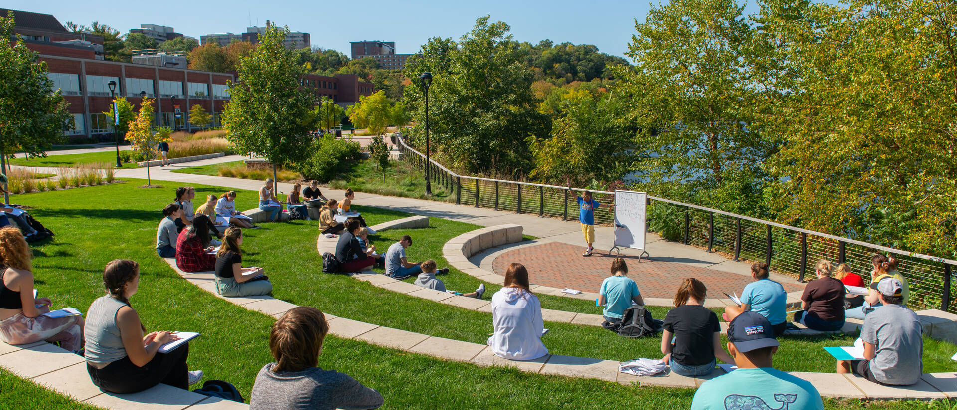 Outdoor classroom taking place on outdoor seating facing the river
