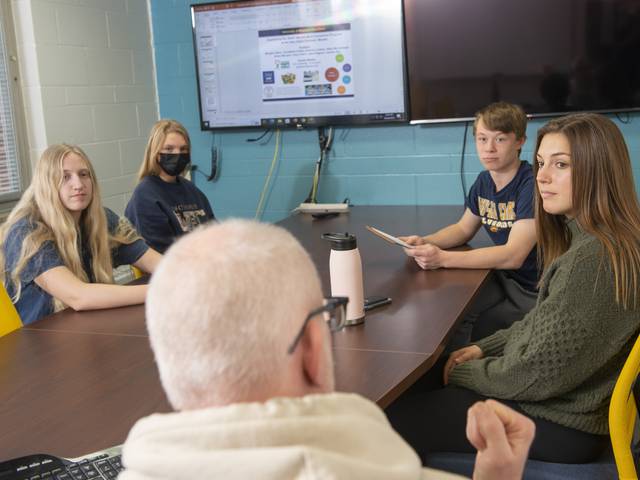 Blugolds (from left) Abby McCullough, Morgan Dekan, Luke Plagens and Annabelle Howat talk with Dr. Eric Jamelske about their research presentation. (Photo by Shane Opatz)