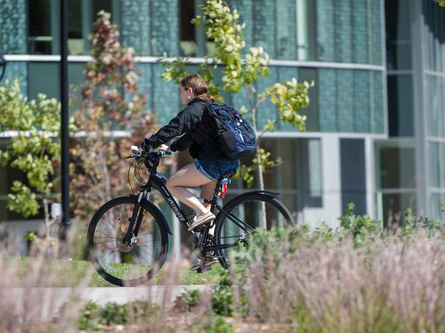 Student biking across campus