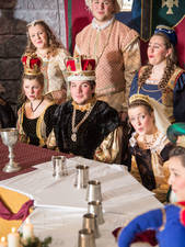 Members of the Ye Olde Madrigal Dinner sitting around the banquet table.