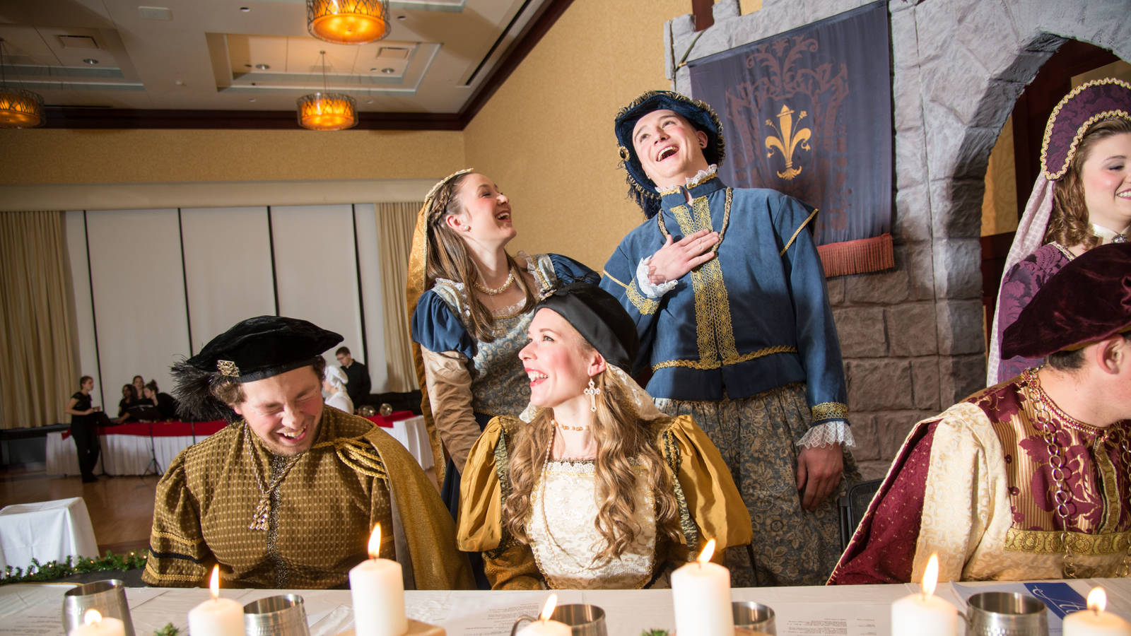 Members of the Ye Olde Madrigal Dinner laughing and talking.