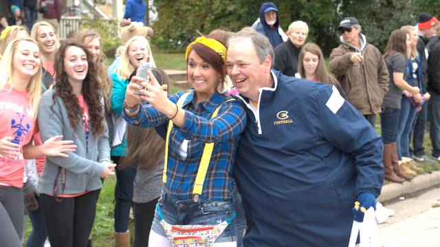Chancellor James Schmidt with students along the parade route during Homecoming 2014.