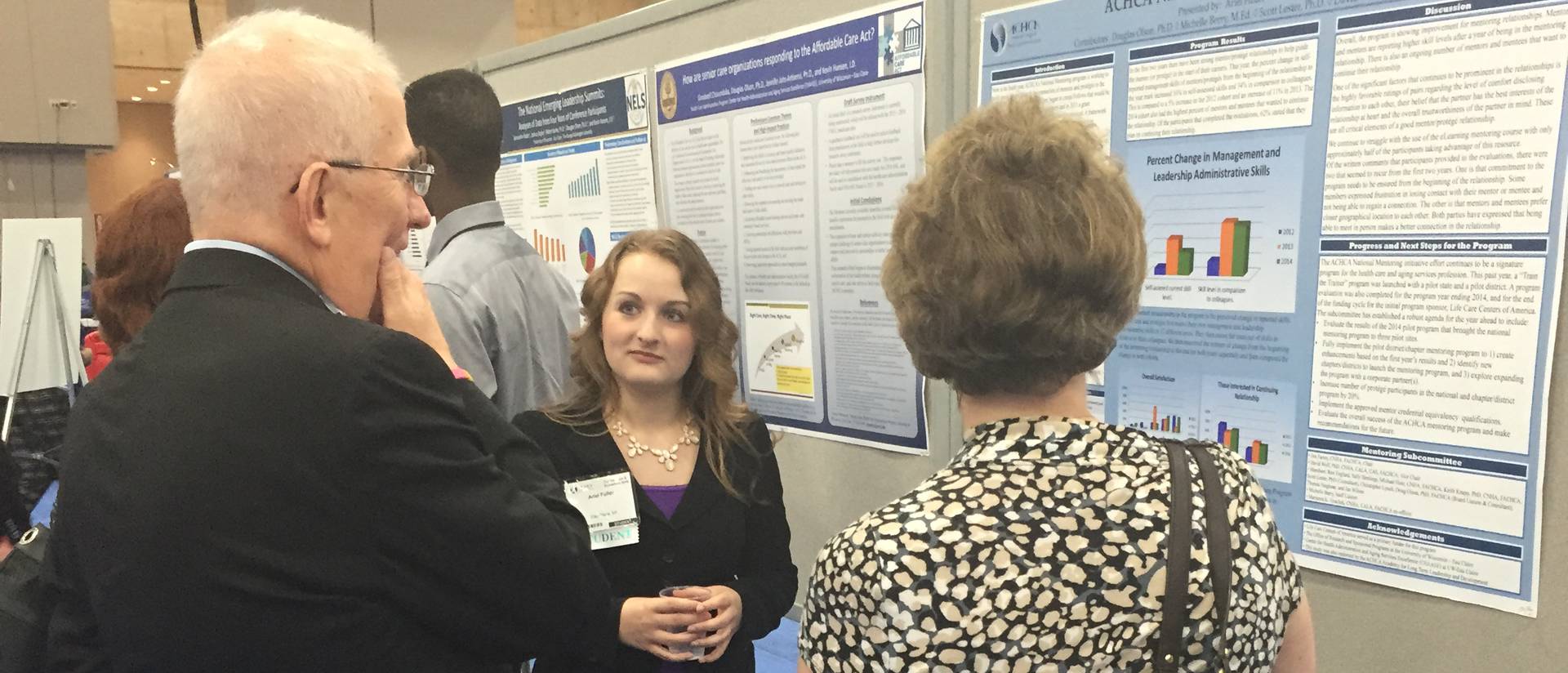 A health care administration student explaining her research project to others.