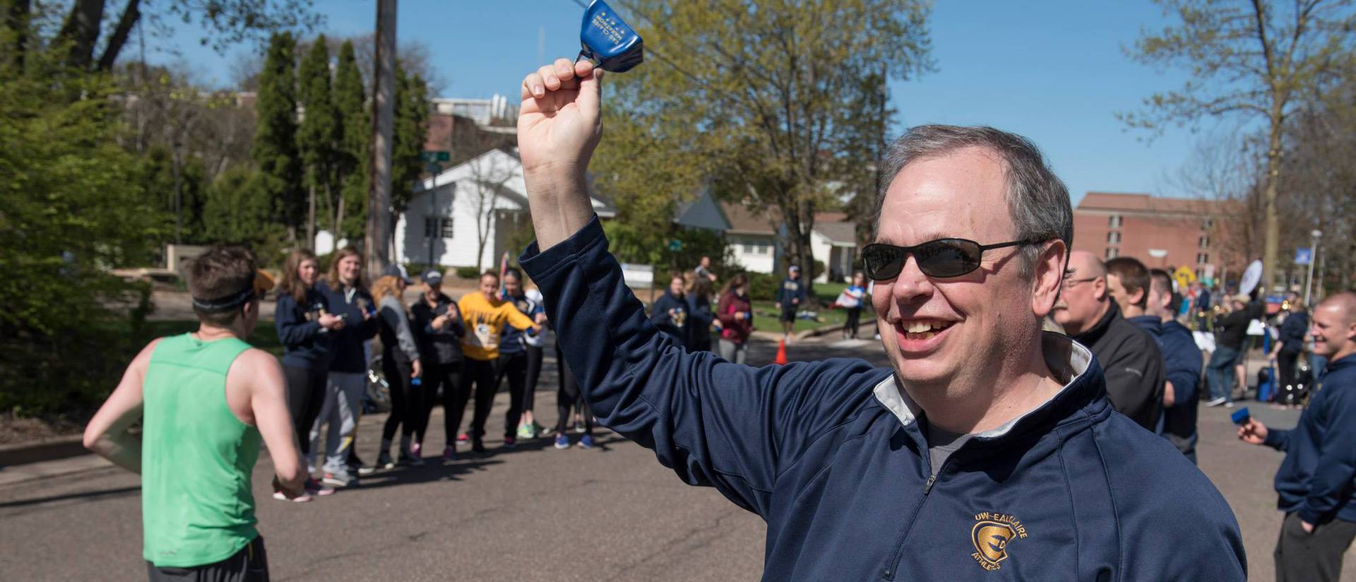 Chancellor Schmidt cheering on runners along the Blugold Mile