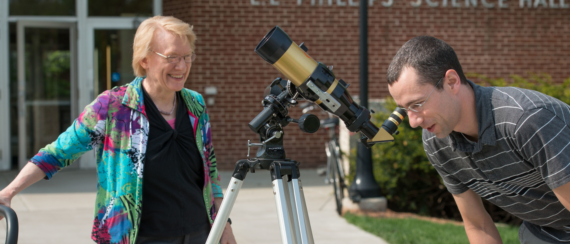 Professor and student looking through telescope