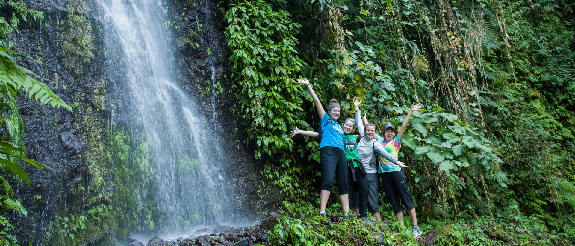 Students in jungle by a waterfall on immersion trip to Guatemala.