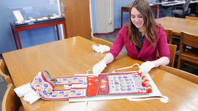 Shelby Miller in special collections working with Indian artifacts. 