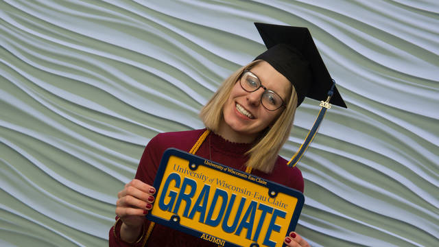 Young woman graduate celebrating at UW-Eau Claire’s Davies Center.